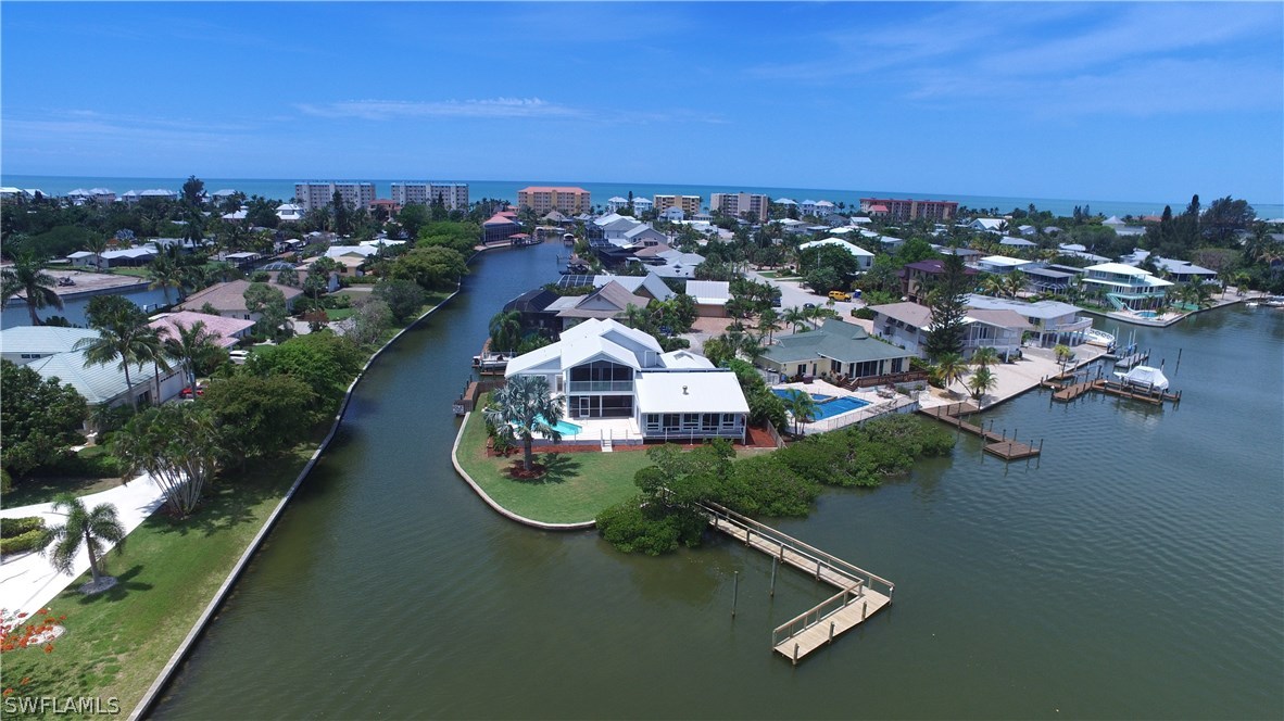 an aerial view of a house with a yard lake and mountain view in back