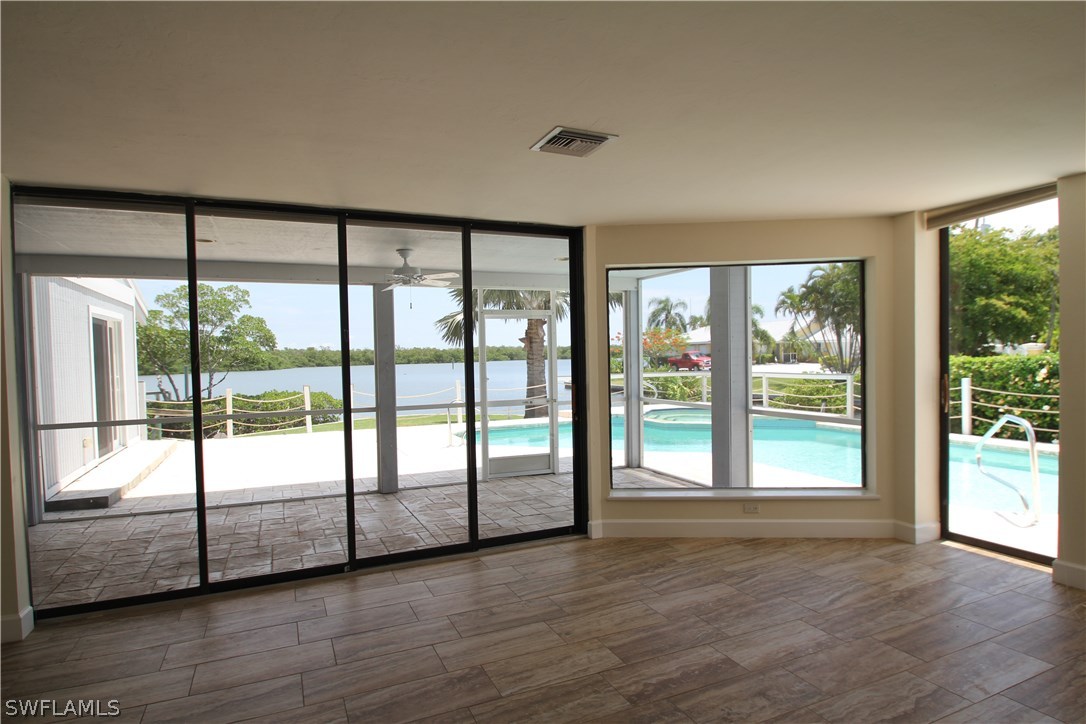 21521 Madera Road Fort Myers Beach, FL 33931 - Photo 12 of 24 a view of an empty room with wooden floor and a window
