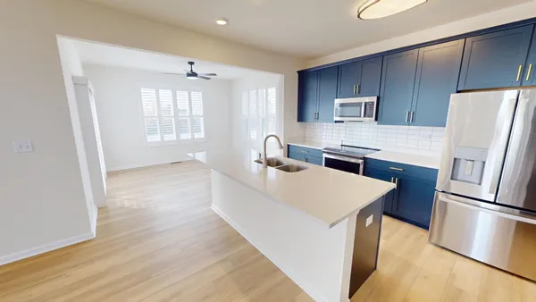 a kitchen with stainless steel appliances a refrigerator sink and wooden floor