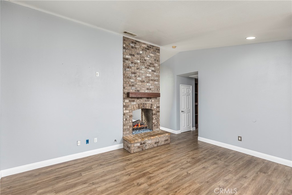 31529 Amsterdam Road Winchester, CA 92596 - Photo 11 of 35 Portion of family room with double-sided fireplace. Entry into breakfast area and kitchen. Hallway down to bedrooms.