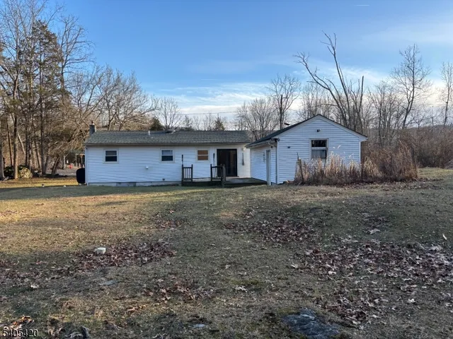 a front view of a house with a garden and tree