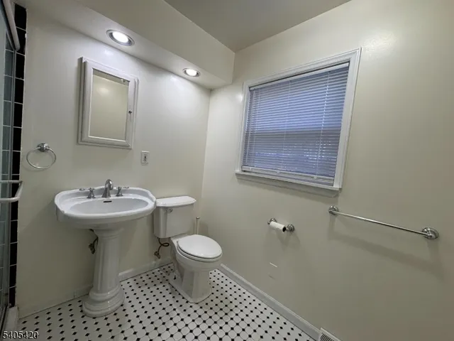 a bathroom with a sink toilet and mirror