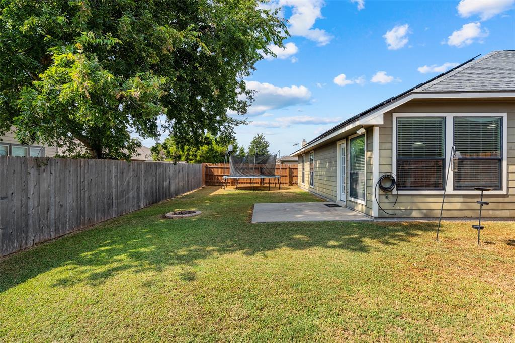 10313 Condor Loop Waco, TX 76708 - Photo 32 of 33 Expansive backyard with a manicured lawn, wood privacy fencing, and a concrete patio