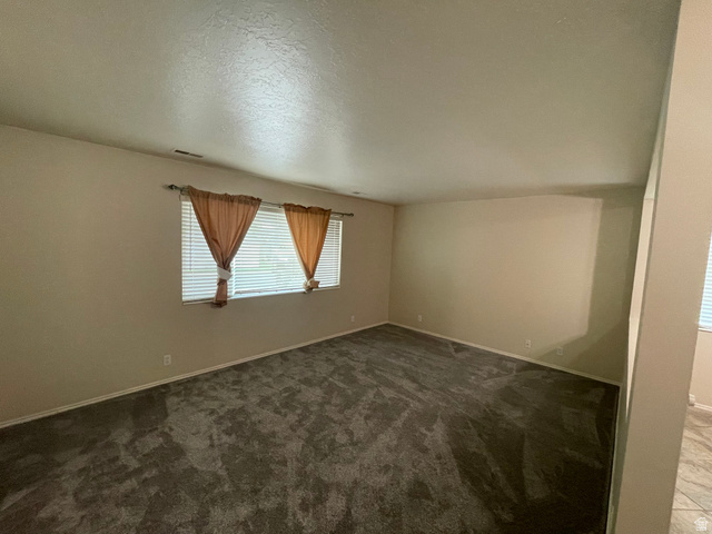 101 1501 Monroe, Unit 101 Ogden, UT 84404 - Photo 3 of 24 Unfurnished room featuring dark colored carpet and baseboards