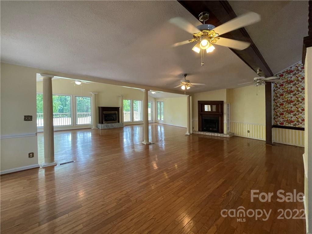 4039 Rounding Run Road Charlotte, NC 28277 - Photo 4 of 28 an empty room with wooden floor and large windows