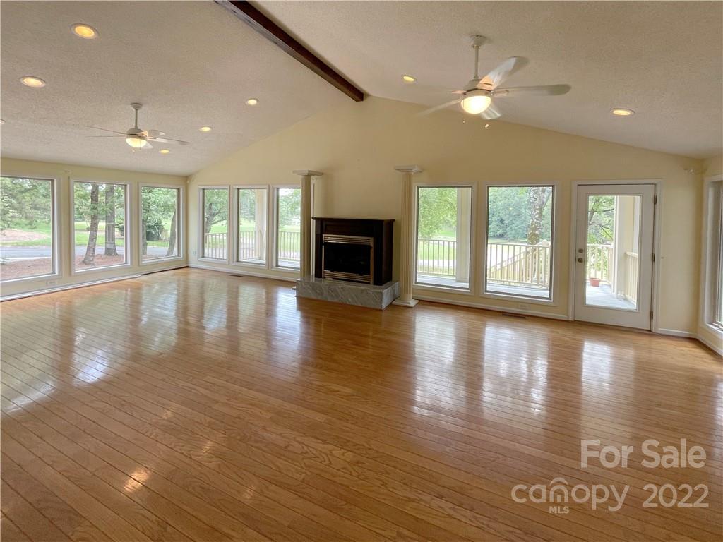 4039 Rounding Run Road Charlotte, NC 28277 - Photo 6 of 28 an empty room with wooden floor and a fireplace