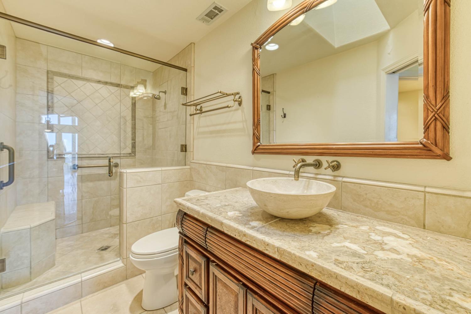 34201 Natoma Road Auberry, CA 93602 - Photo 13 of 40 a bathroom with a granite countertop sink a toilet and shower