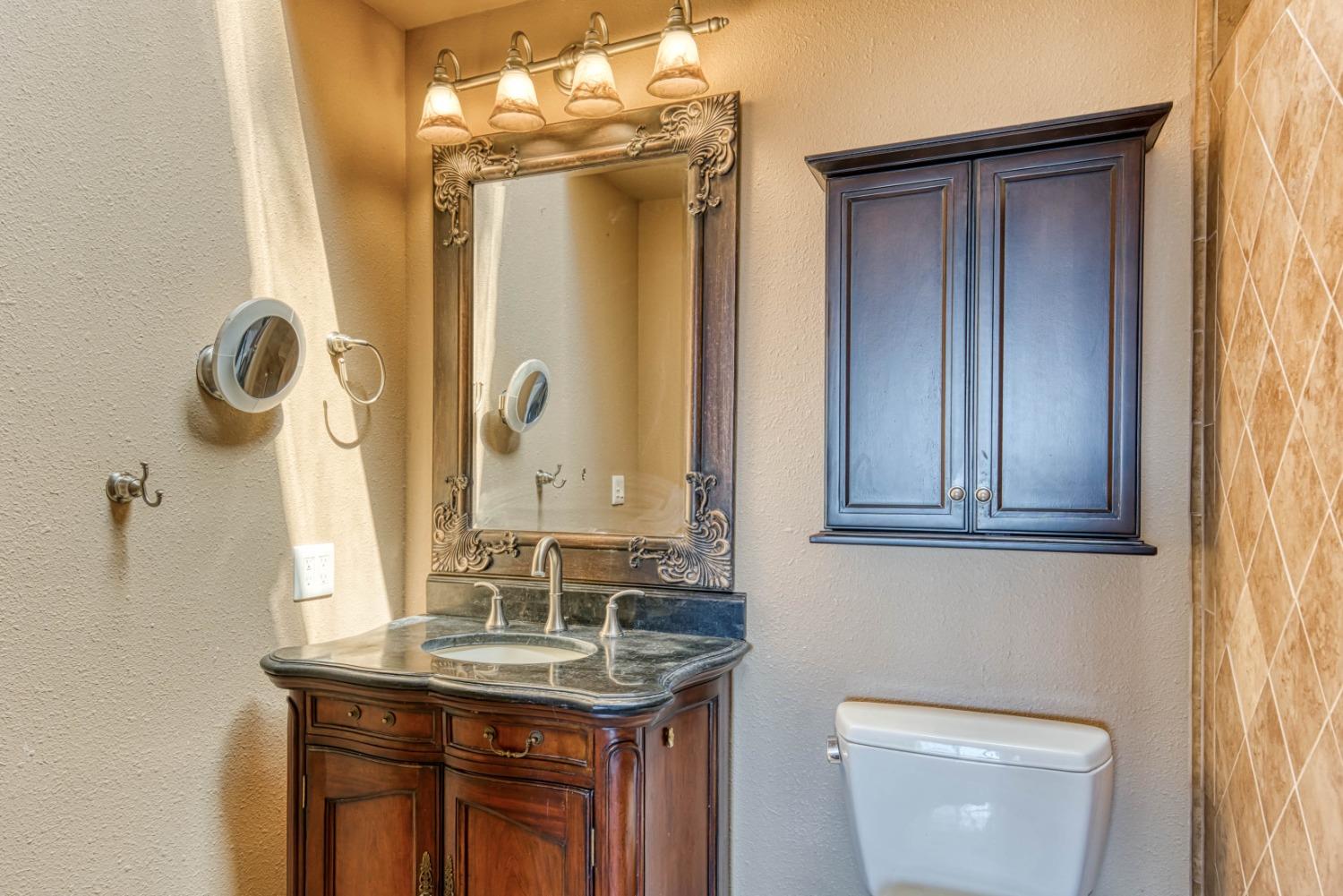34201 Natoma Road Auberry, CA 93602 - Photo 16 of 40 a bathroom with a granite countertop sink a toilet and a mirror