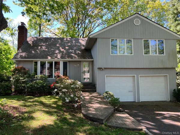 a front view of house with yard and trees around