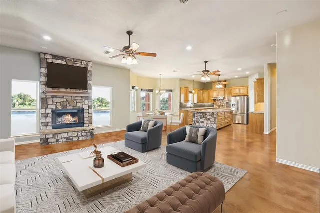 a living room with furniture a flat screen tv and kitchen view