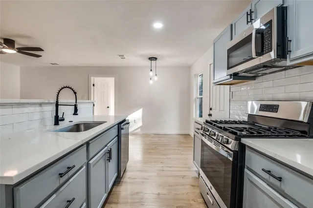 a kitchen with stainless steel appliances granite countertop a stove and a microwave