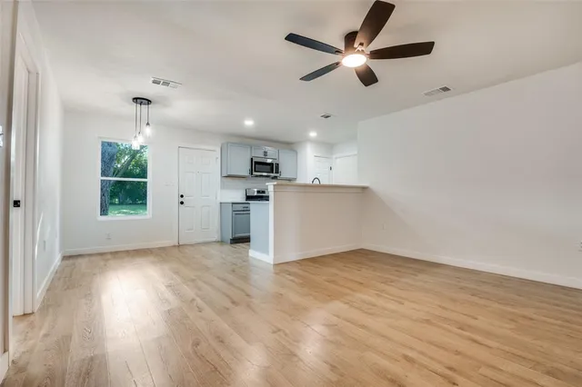 a view of kitchen with wooden floor a ceiling fan and kitchen space