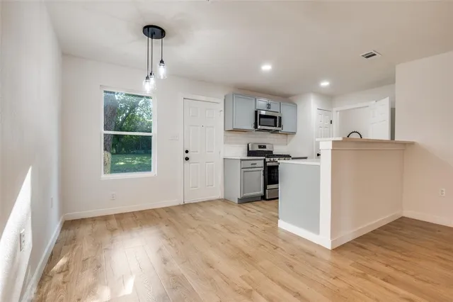 a kitchen with kitchen island white cabinets and wooden floor