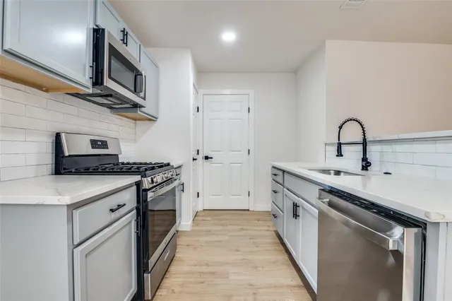 a view of a kitchen with a sink cabinets and wooden floor
