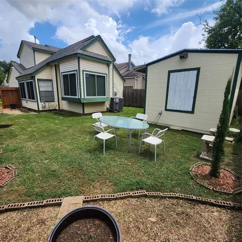 a view of a house with backyard and sitting area