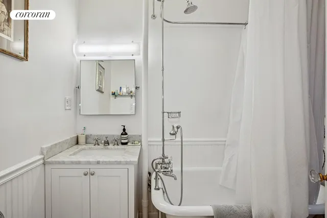 a spacious bedroom with a bed and a chandelier