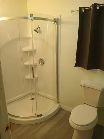 a large kitchen with stainless steel appliances kitchen island granite countertop a sink and a stove top oven with wooden floor