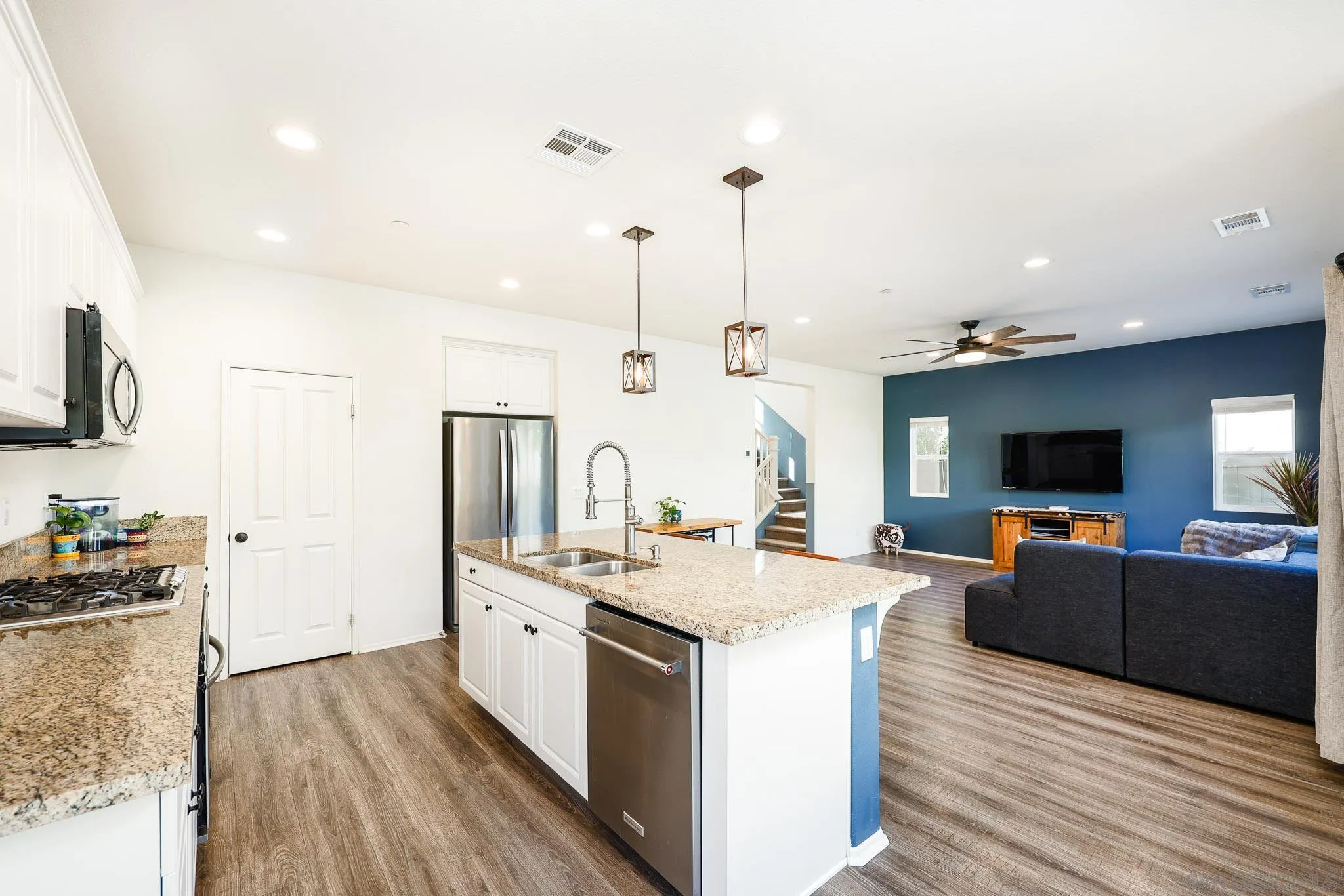 310 Falabella Lane Fallbrook, CA 92028 - Photo 16 of 48 a large kitchen with stainless steel appliances kitchen island granite countertop a sink stove and wooden floor
