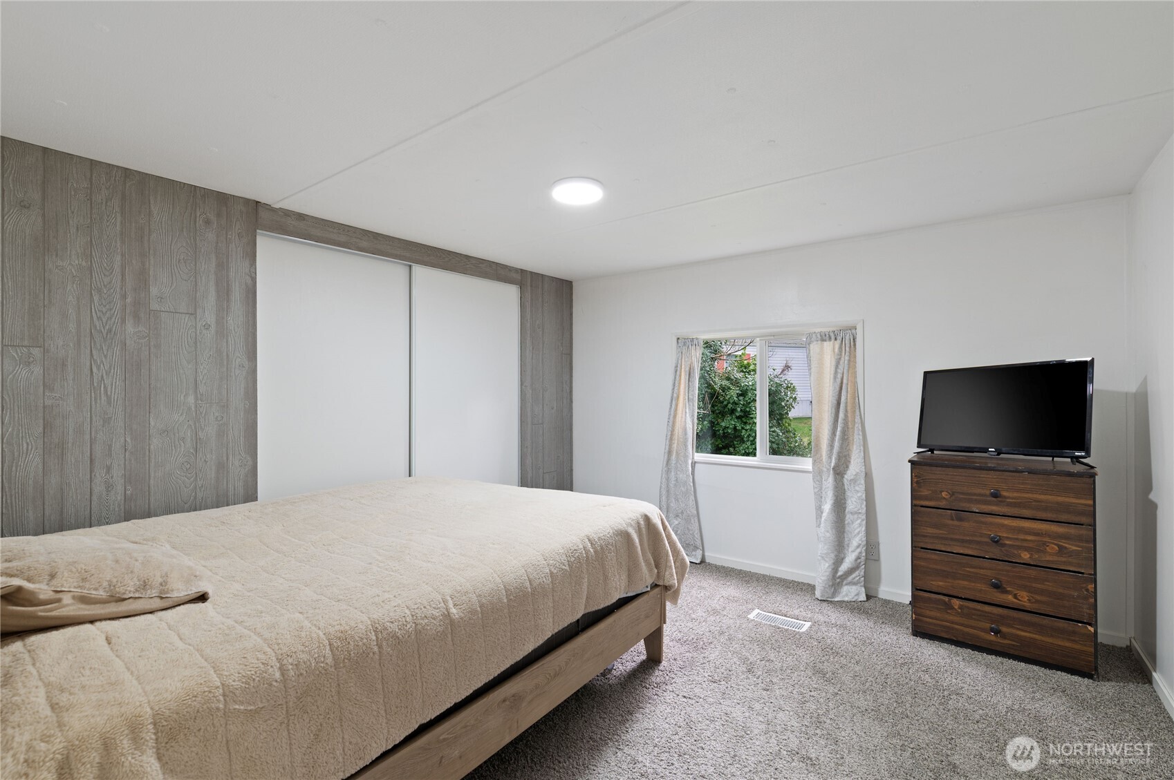 3060 Northeast McWilliams Road, Unit 122 Bremerton, WA 98311 - Photo 17 of 20 a bedroom with a bed and a television