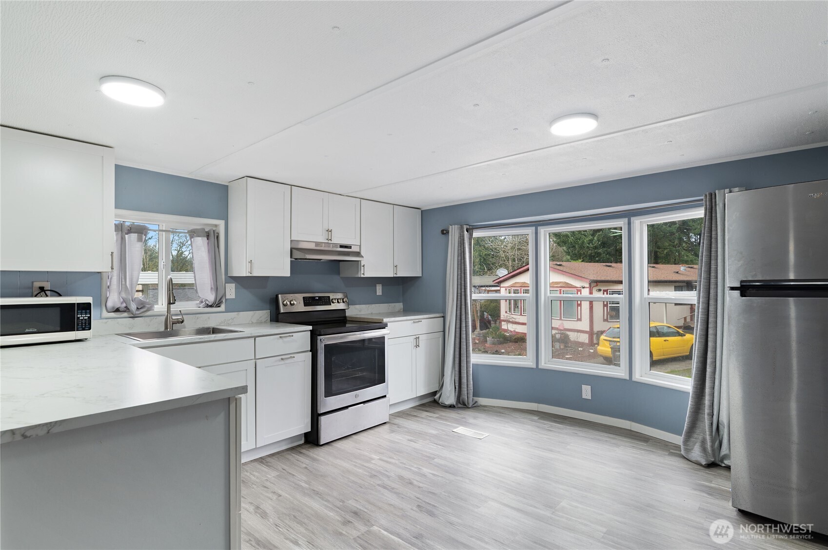 3060 Northeast McWilliams Road, Unit 122 Bremerton, WA 98311 - Photo 3 of 20 a kitchen with granite countertop a stove a sink and a refrigerator