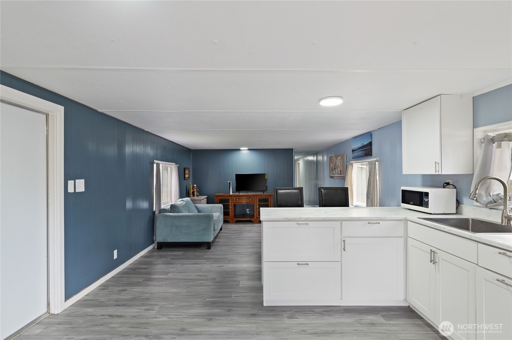 3060 Northeast McWilliams Road, Unit 122 Bremerton, WA 98311 - Photo 6 of 20 a kitchen with stainless steel appliances kitchen island granite countertop a refrigerator sink and white cabinets