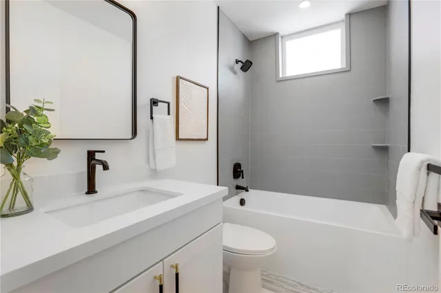 a bathroom with a sink a toilet a mirror and shower