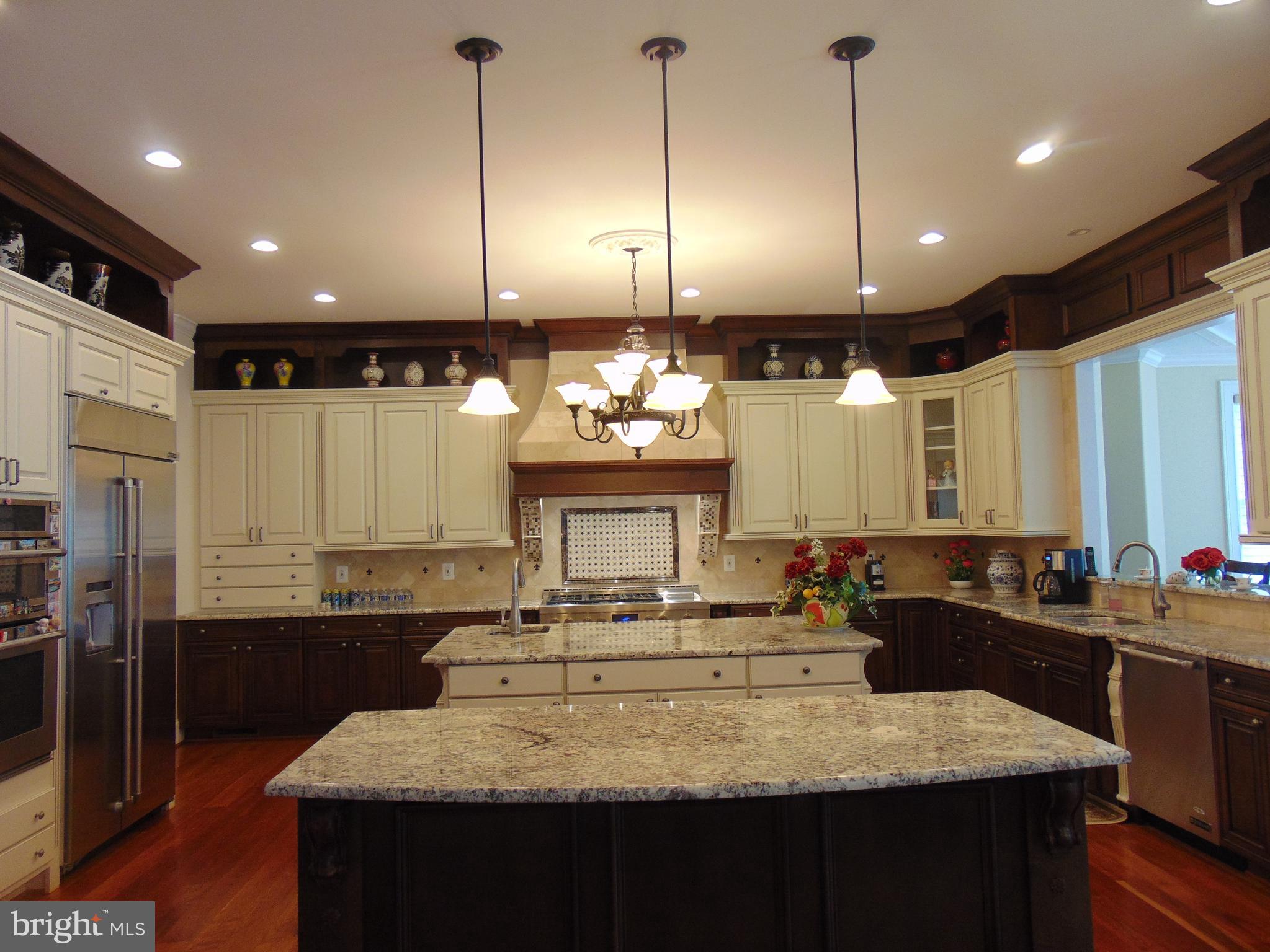 1027 Towlston Road McLean, VA 22102 - Photo 52 of 59 a kitchen with kitchen island granite countertop a stove a sink a refrigerator a oven island and couches with wooden floor