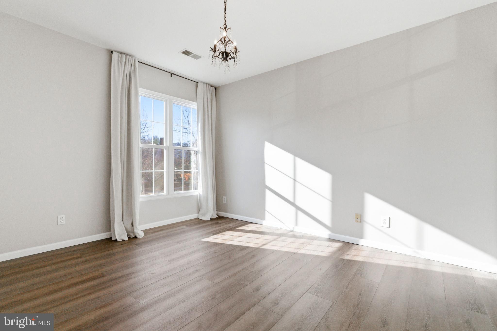 20419 Riverbend Square, Unit 200 Sterling, VA 20165 - Photo 16 of 39 a view of an empty room with wooden floor and a window