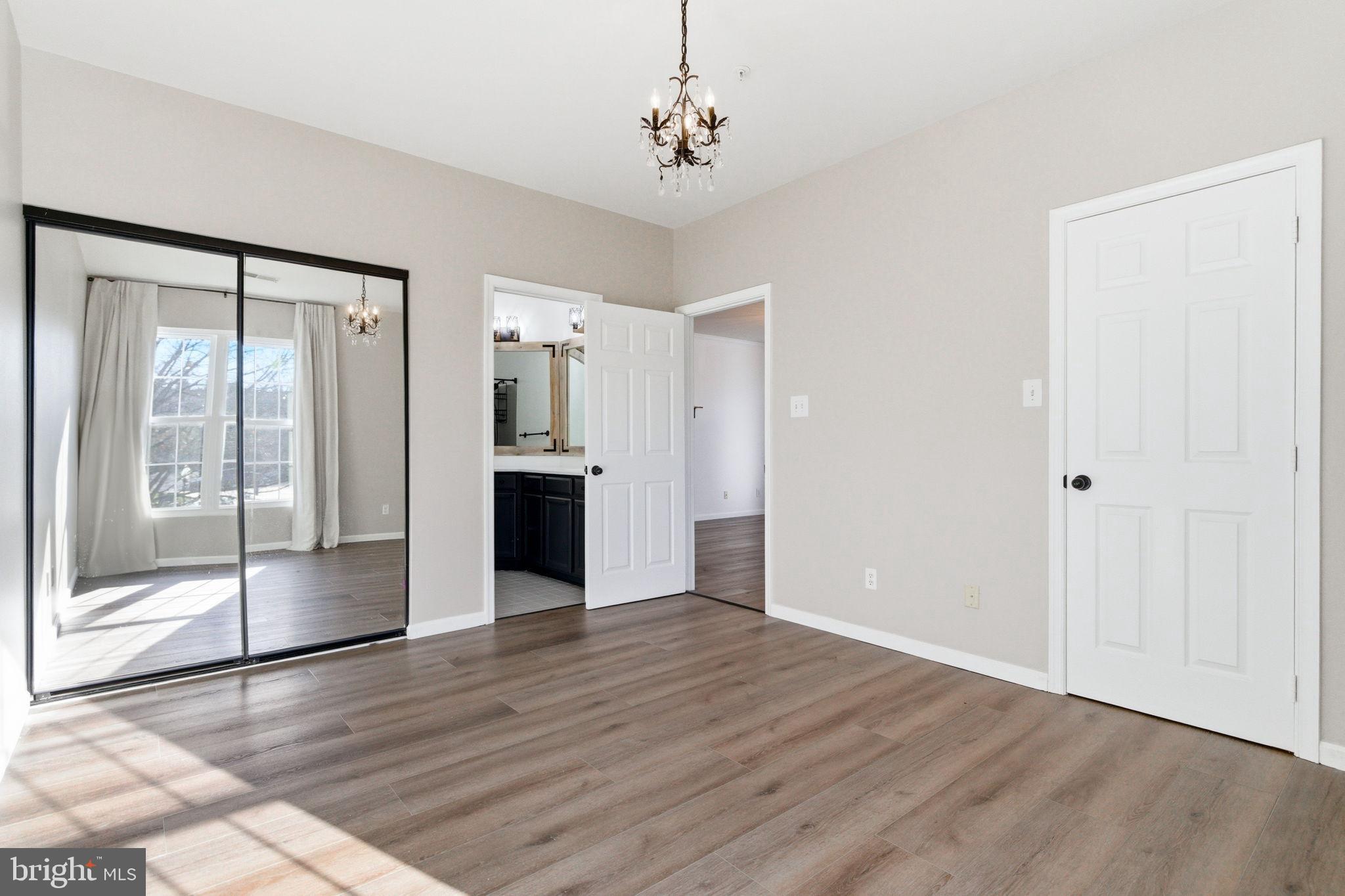 20419 Riverbend Square, Unit 200 Sterling, VA 20165 - Photo 18 of 39 a view of an empty room with wooden floor and a kitchen