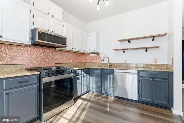 a kitchen with granite countertop cabinets stainless steel appliances and a counter space