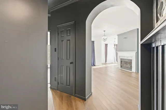 a view of a hallway with wooden floor and a kitchen