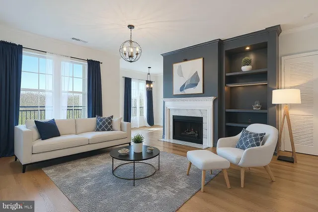 a living room with furniture a fireplace and a large mirror