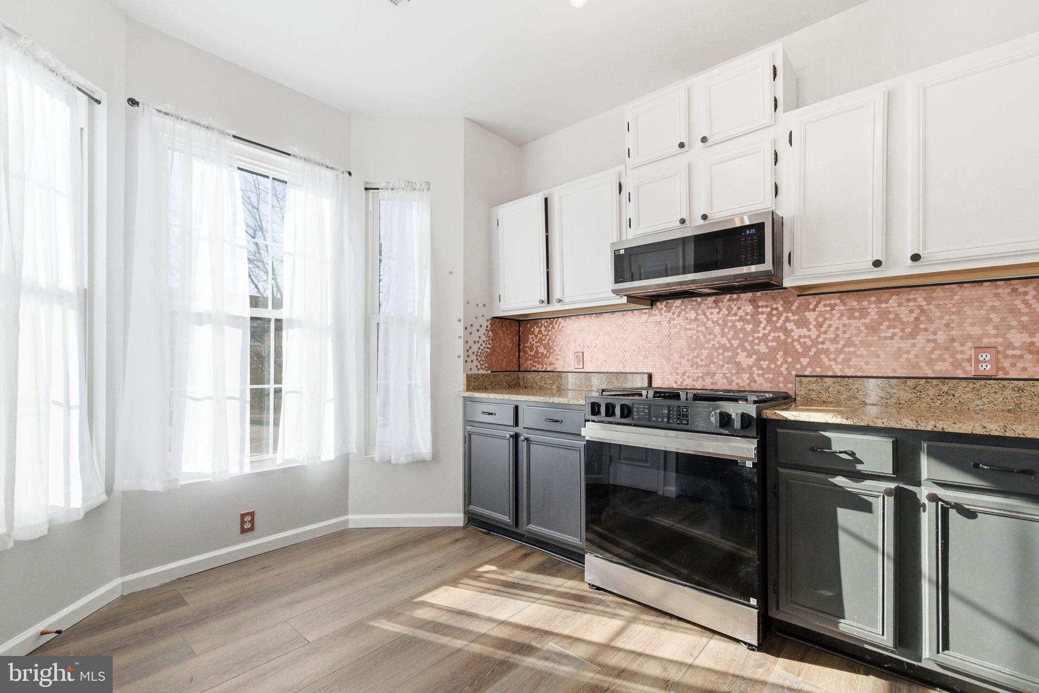 20419 Riverbend Square, Unit 200 Sterling, VA 20165 - Photo 5 of 39 a kitchen with stainless steel appliances granite countertop a stove a sink and a microwave