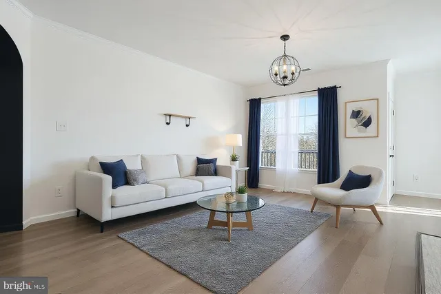 a living room with furniture a rug a lamp and a window