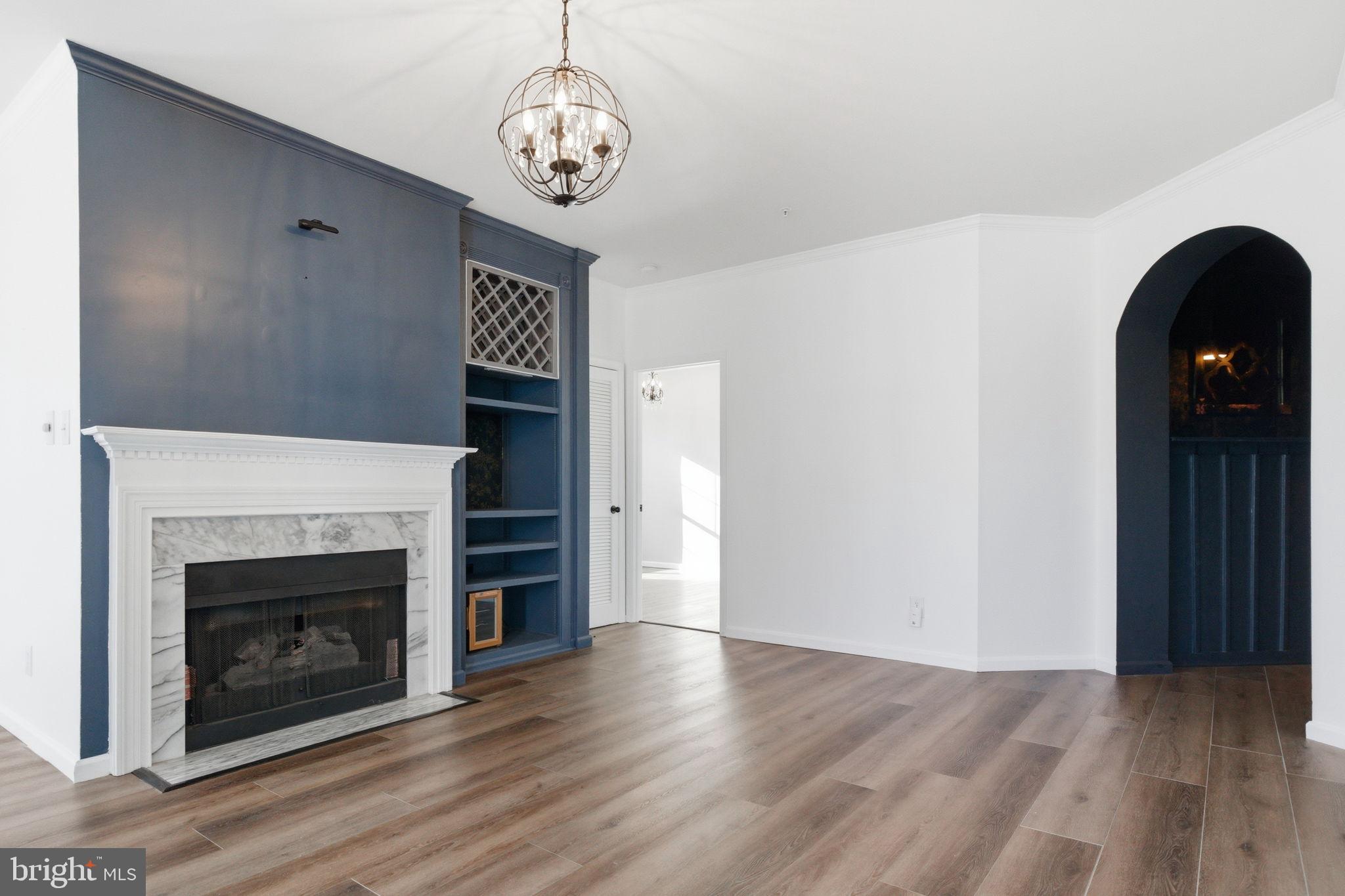 20419 Riverbend Square, Unit 200 Sterling, VA 20165 - Photo 8 of 39 a view of an empty room with wooden floor fireplace and a window