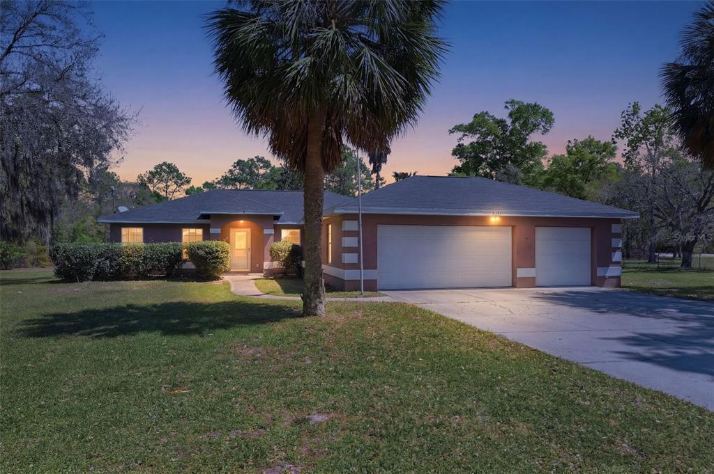 8681 Southwest 140th Avenue Dunnellon, FL 34432 - Photo 1 of 1 a front view of house with yard and trees