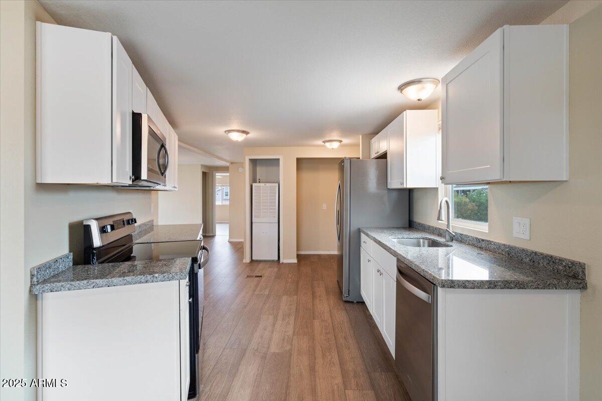 320 East McKellips Road, Unit 211 Mesa, AZ 85201 - Photo 14 of 27 a kitchen with granite countertop a sink stove and cabinets