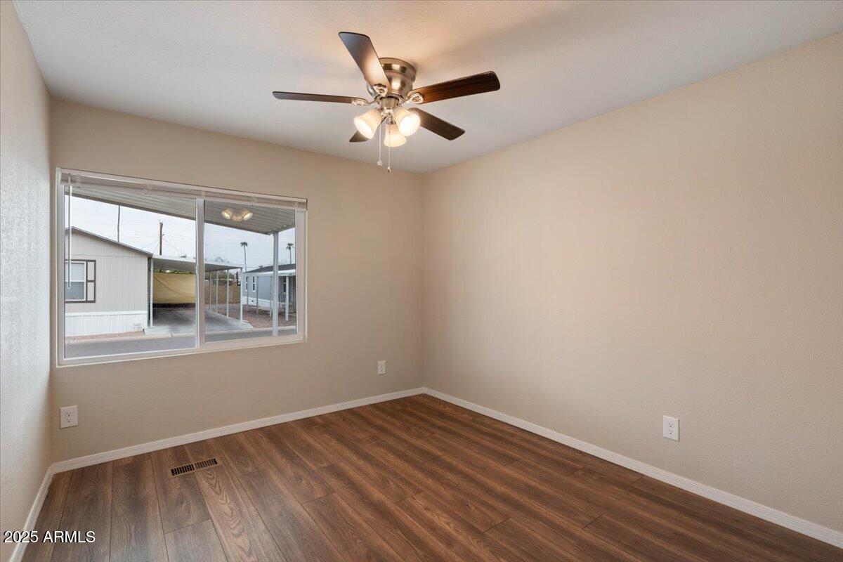 320 East McKellips Road, Unit 211 Mesa, AZ 85201 - Photo 16 of 27 an empty room with wooden floor fan and windows