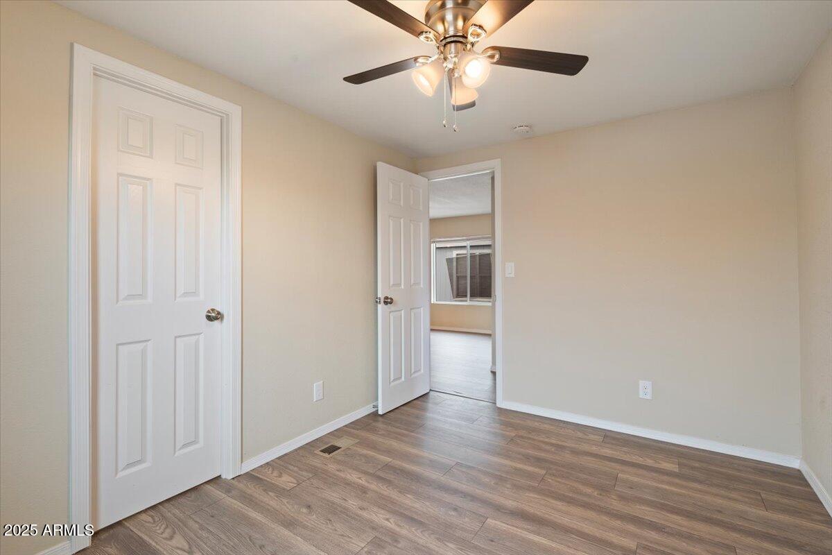 320 East McKellips Road, Unit 211 Mesa, AZ 85201 - Photo 25 of 27 an empty room with wooden floor closet and windows