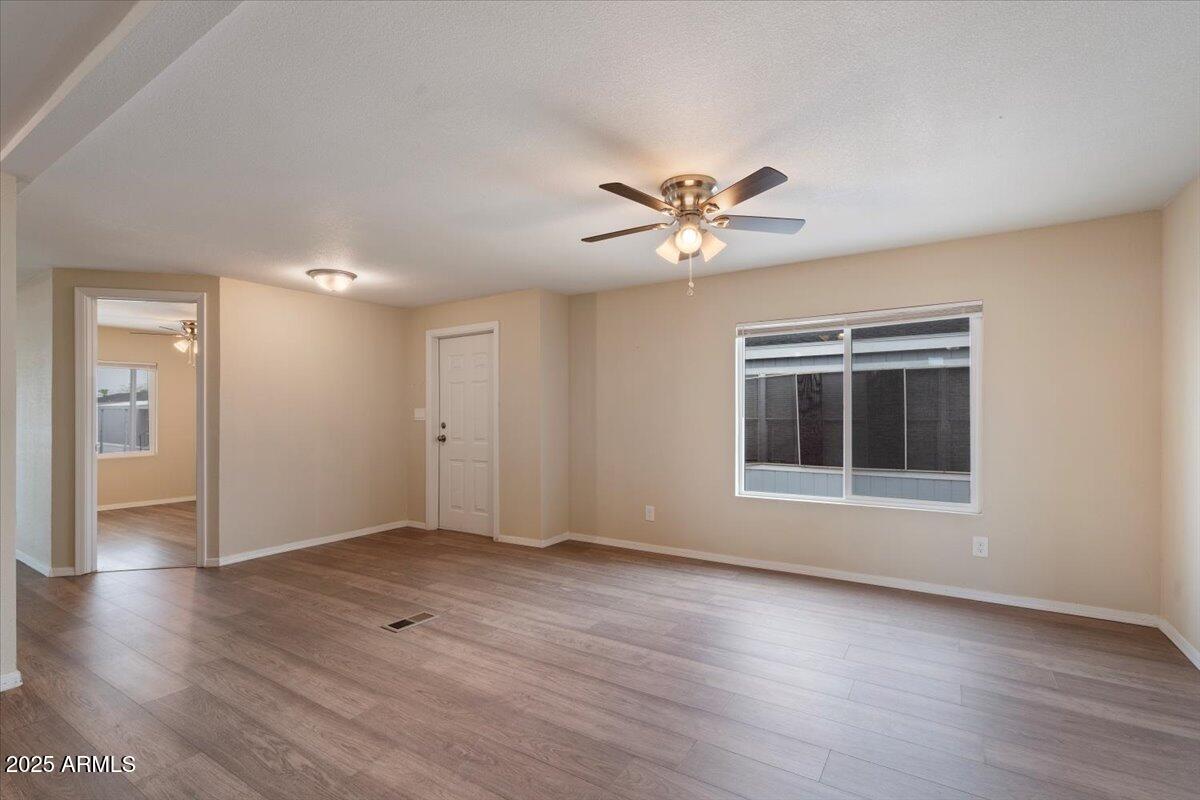 320 East McKellips Road, Unit 211 Mesa, AZ 85201 - Photo 9 of 27 a view of an empty room with a window and wooden floor
