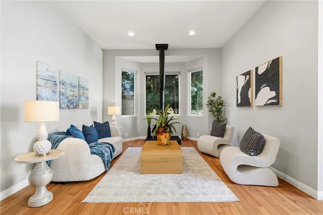 a living room with furniture and a large mirror next to a window