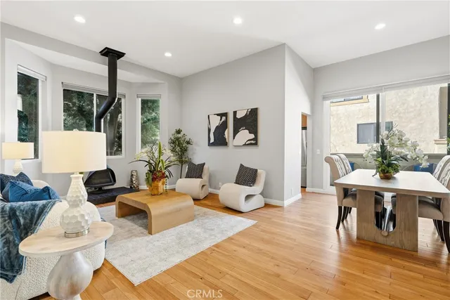a living room with furniture large window and wooden floor
