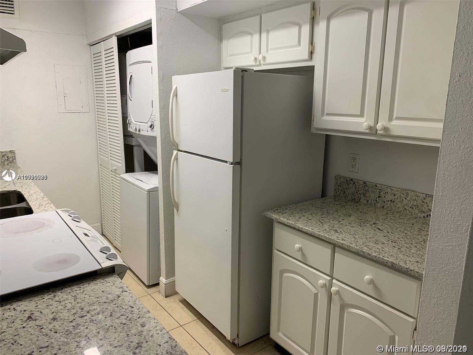 4537 Treehouse Lane, Unit C Tamarac, FL 33319 - Photo 4 of 11 a kitchen with stainless steel appliances white cabinets and a refrigerator