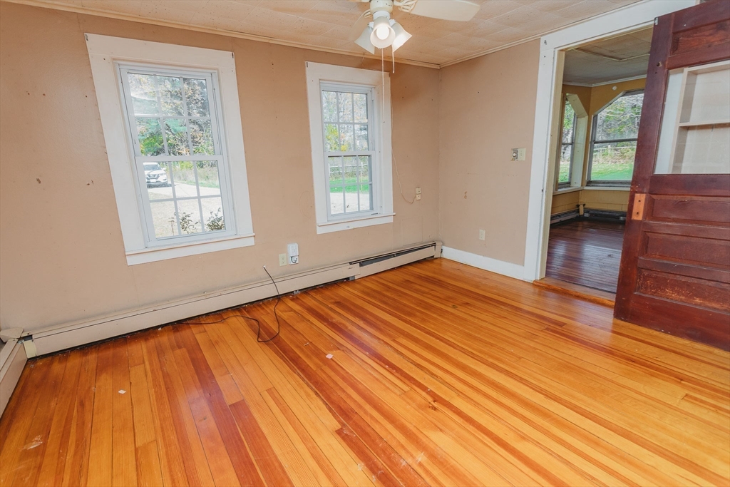 163 Hazelton Road Rowe, MA 01367 - Photo 8 of 40 a view of an empty room with wooden floor and a window