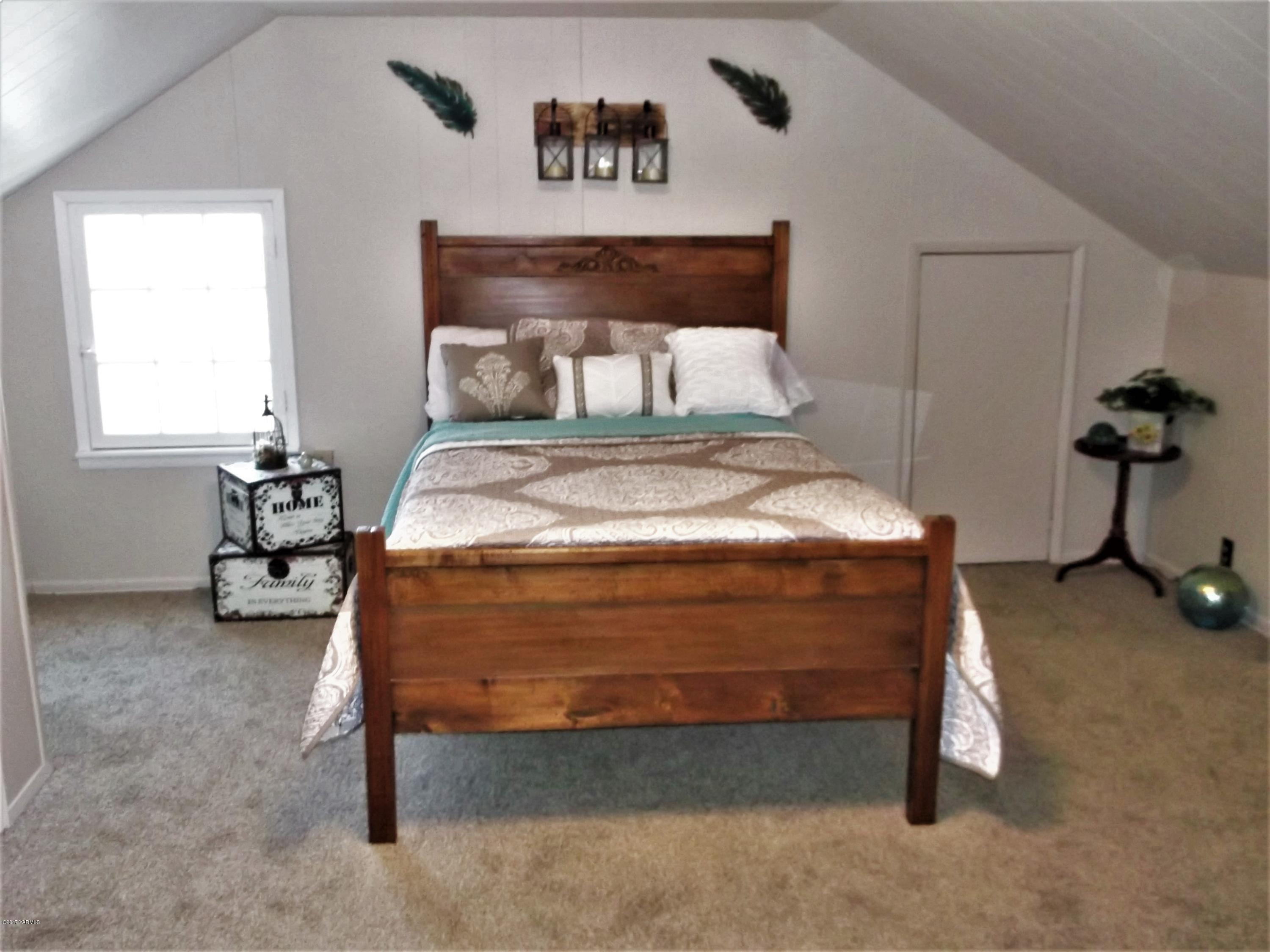 2000 Hornby Road Grandview, WA 98930 - Photo 11 of 45 a bed sitting in a bedroom next to a window with a lamp and a table