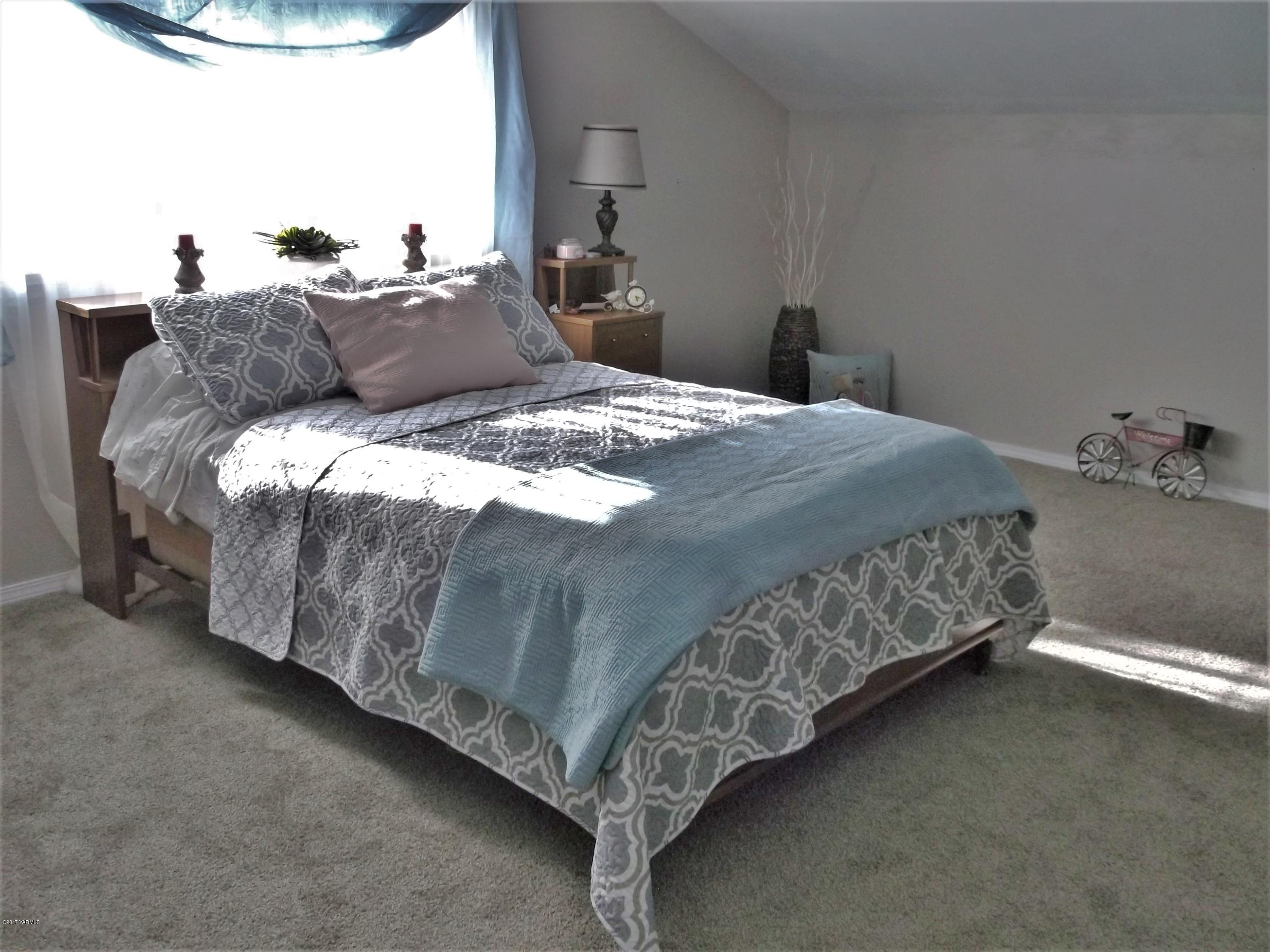 2000 Hornby Road Grandview, WA 98930 - Photo 24 of 45 a bed sitting in a bedroom next to a lamp
