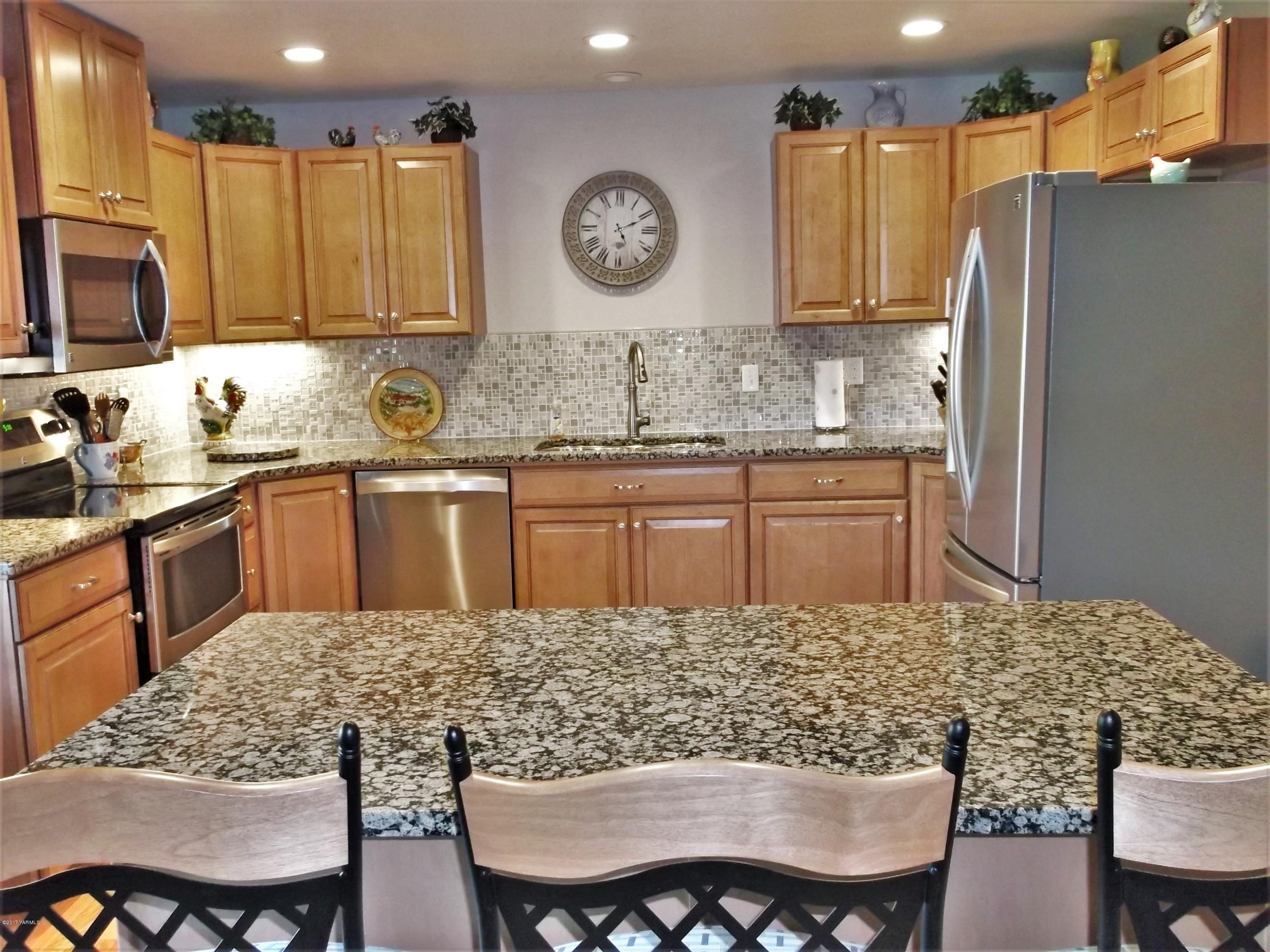 2000 Hornby Road Grandview, WA 98930 - Photo 8 of 45 a kitchen with stainless steel appliances granite countertop a sink refrigerator stove dining table and chairs