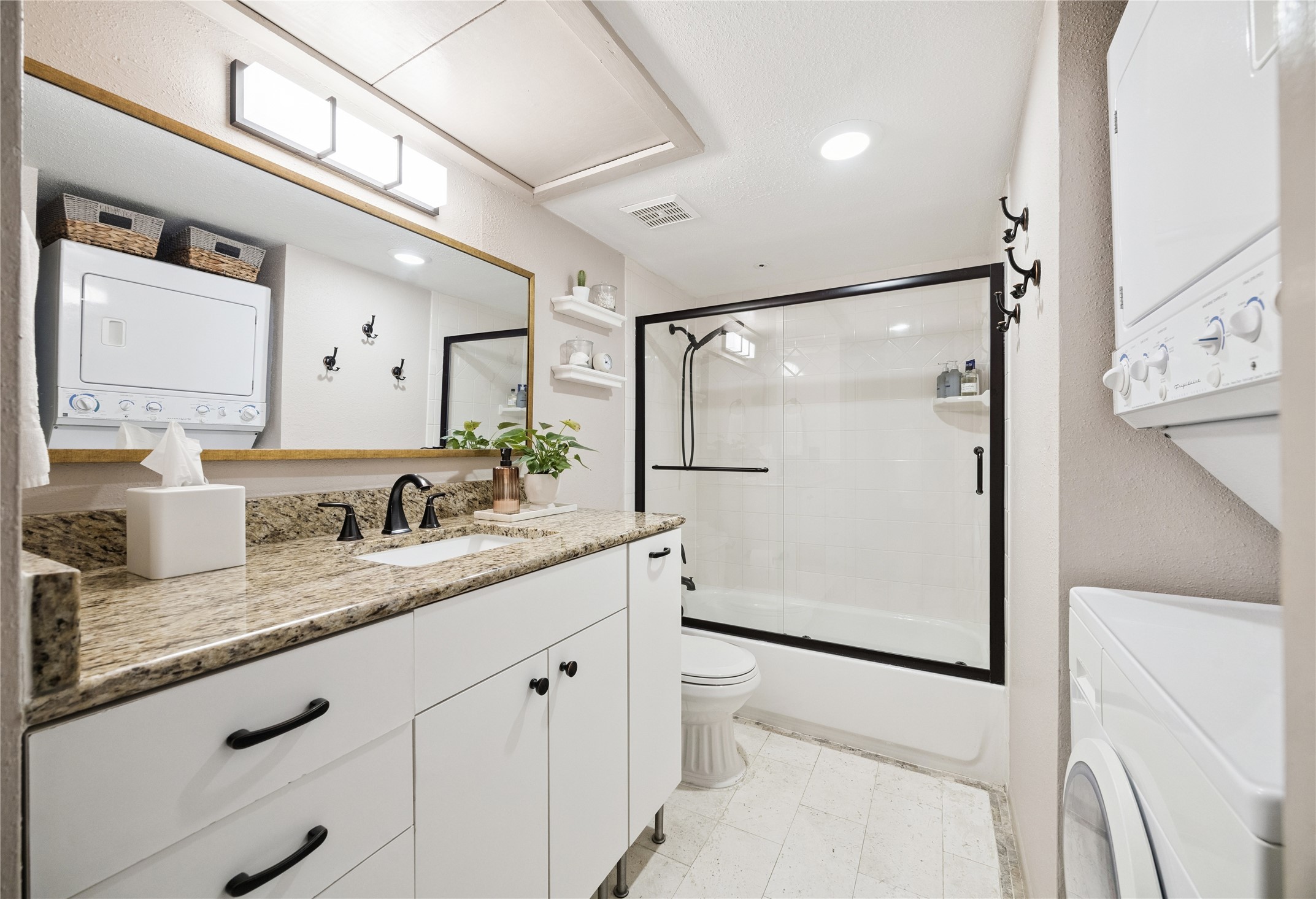 7555 Katy Freeway, Unit 50 Houston, TX 77024 - Photo 12 of 13 a bathroom with a granite countertop sink mirror vanity and toilet