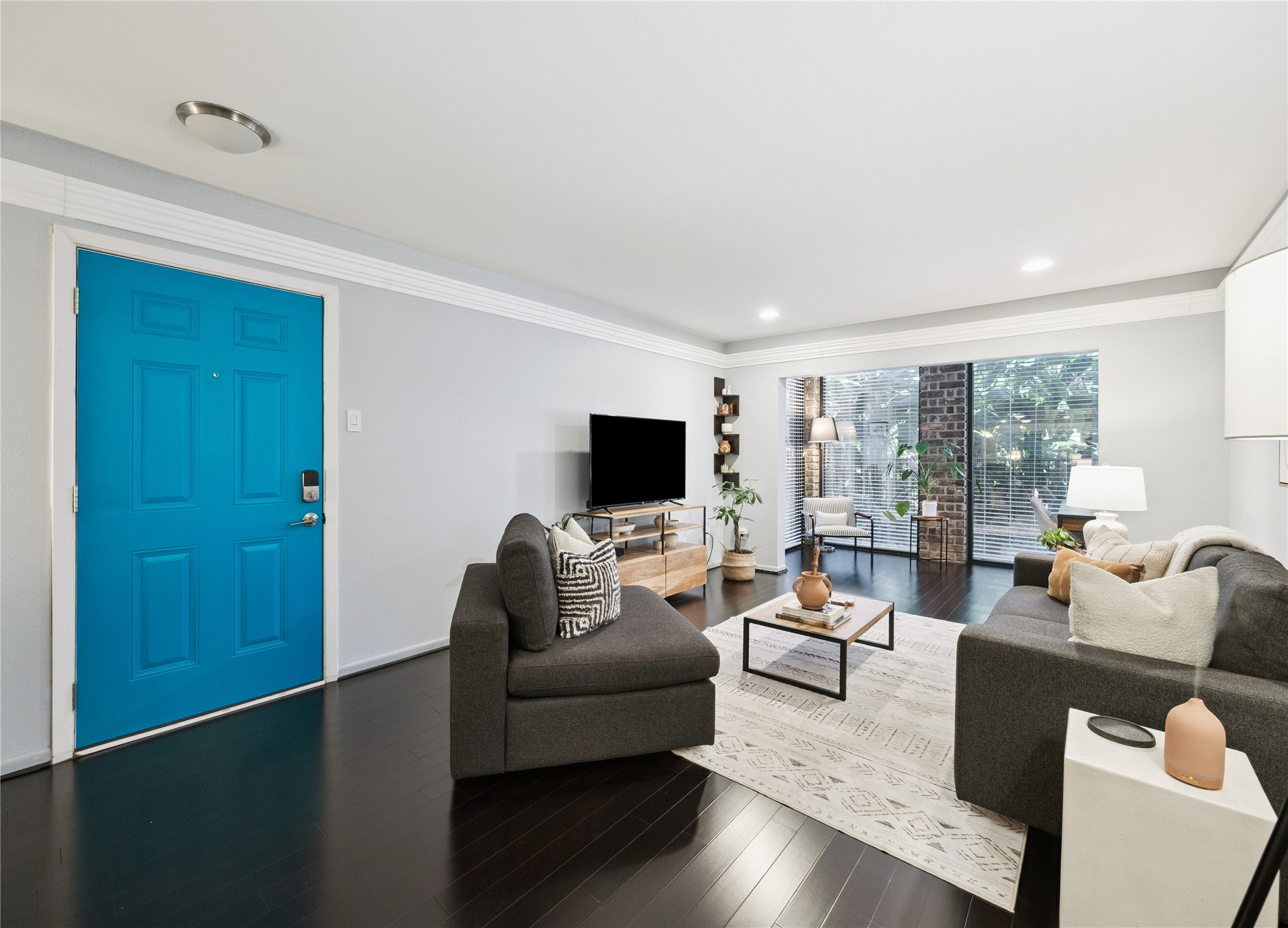 7555 Katy Freeway, Unit 50 Houston, TX 77024 - Photo 7 of 13 a living room with furniture wooden floor and a flat screen tv