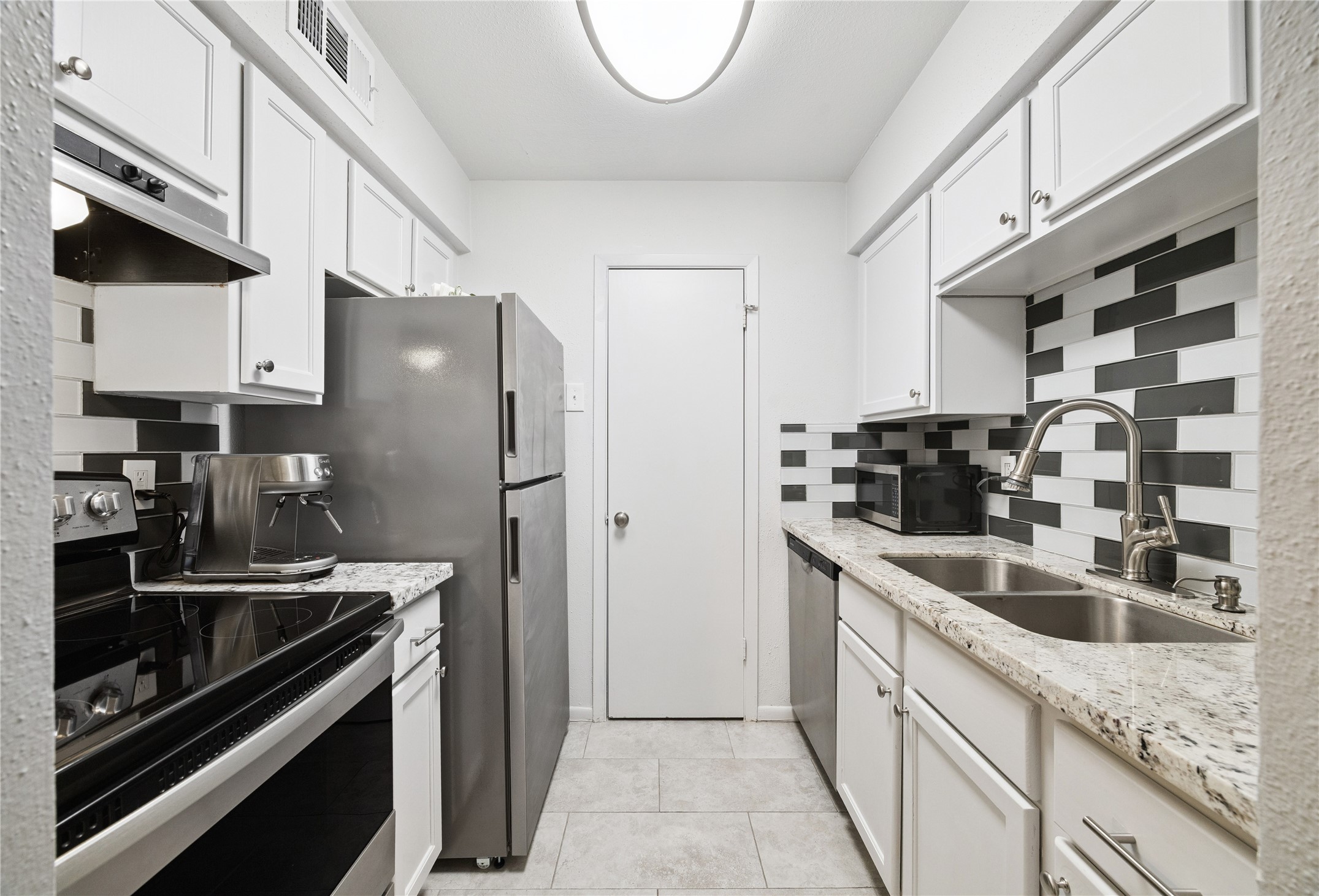 7555 Katy Freeway, Unit 50 Houston, TX 77024 - Photo 9 of 13 a kitchen with stainless steel appliances granite countertop a sink stove and refrigerator